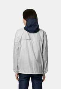 Giacca leggera, grigia e resistente all'acqua con cappuccio navy, polsini elasticizzati e cordino in fondo; texture liscia e design semplice.