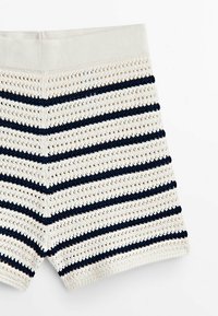 Pantaloni corti a maglia a righe con vita beige chiaro. Presentano righe alternate blu navy e beige e una trama a tessitura aperta.