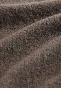 Brown woolen fabric featuring a soft, textured surface with subtle variations in shade and a pronounced weave pattern.