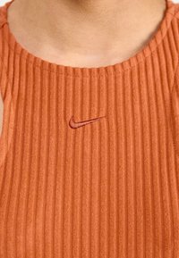 Nike bezrukávový top, ribovaná textura, oranžová barva, zdobený malým vyšitým logem v tmavě oranžové, kulatý výstřih, přiléhavý střih.