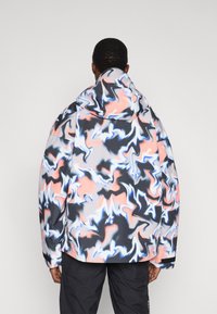 Giacca con cappuccio multicolore con un motivo a vortice nero, rosa e blu. Realizzata in tessuto liscio e leggero con una vestibilità morbida.