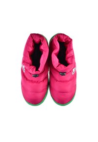 Zapatillas de felpa rosas con puños elásticos, suelas de goma verdes y cierres de toggles negros; textura suave con detalle del logo en el costado.