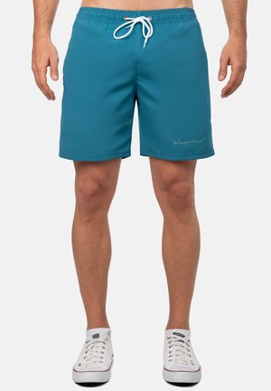 Shorts de bain teal avec une taille élastique et un cordon blanc. Présente un détail de logo subtil et un matériau lisse et léger.
