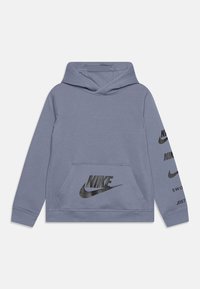Sweat-shirt à capuche gris avec une poche frontale, arborant des logos Nike noirs sur la poitrine et la manche. Fabriqué en matériau doux avec une coupe standard.