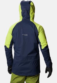 Giacca impermeabile navy e verde lime con cappuccio, materiale testurizzato e polsini elastici. Presenta il logo Columbia Titanium sul retro.