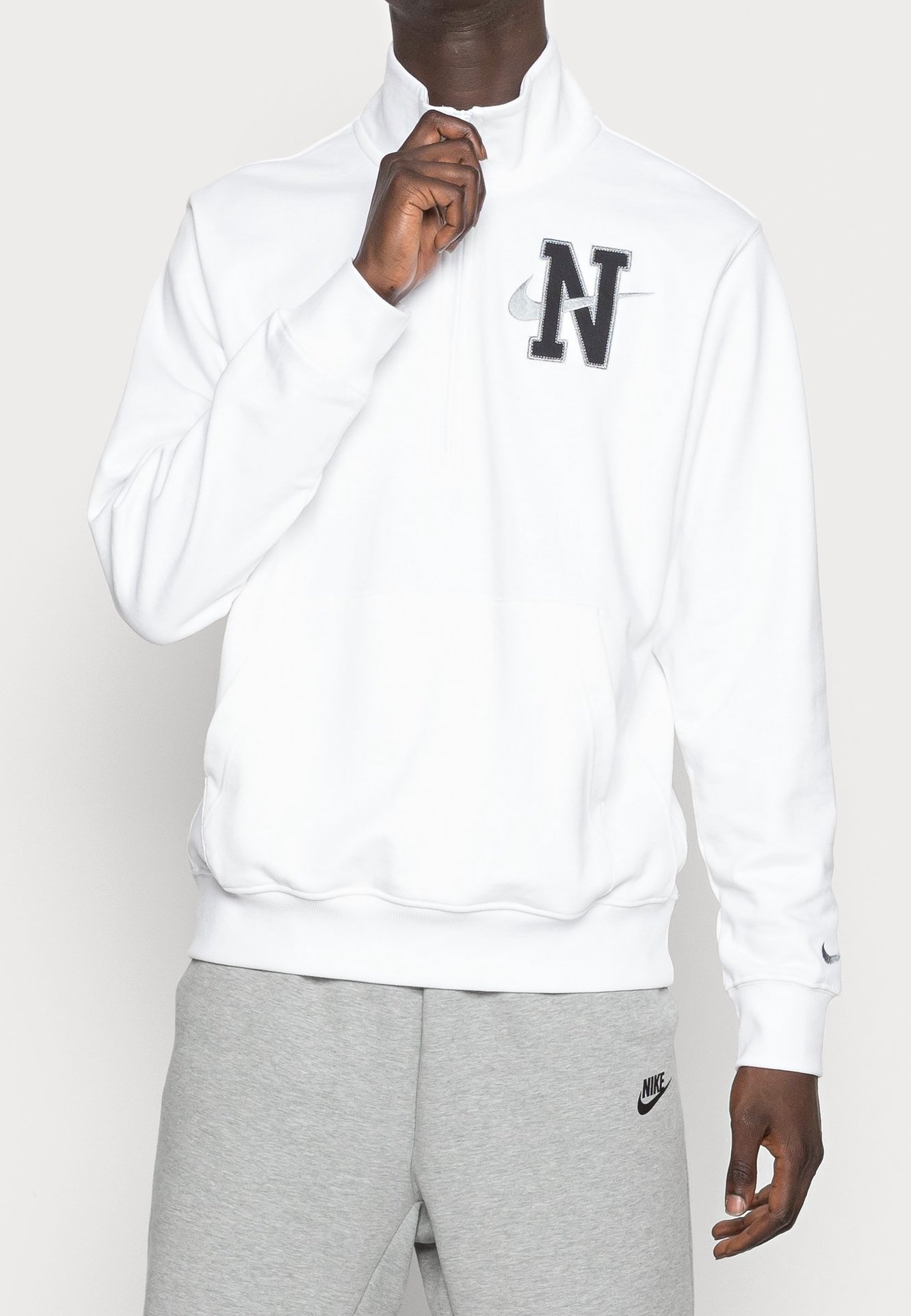 white nike jumper with black ticks all over
