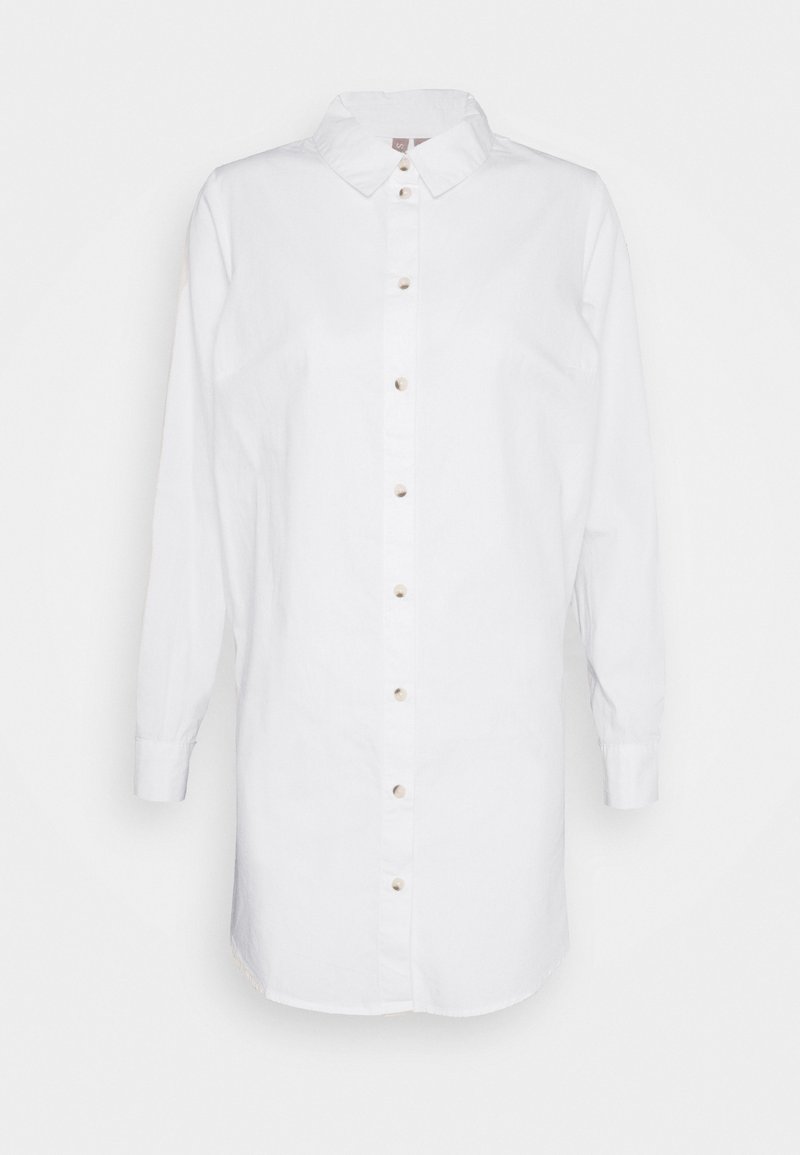 Chemise blanche longue à boutons avec col et manches longues, présentée sur un fond blanc uni.