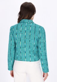 Jachetă din tweed turcoaz cu un guler structurat, mâneci lungi și un model vertical multicolor. Design ajustat, lungime scurtă.