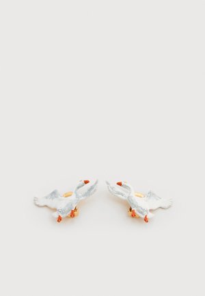 Clous d'oreilles en céramique en forme de canard avec corps blancs, becs orange et accessoires ton or, présentant des ailes en relief et des textures détaillées.