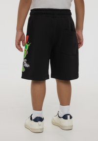 Shorts neri in cotone, con una grafica cartoon colorata di lato, vita elasticizzata e dettagli di tasca sul retro.