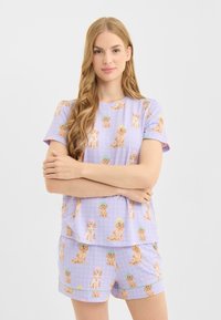 Lila pyjama set met een ruitpatroon en meerdere geïllustreerde honden. Kort mouwen top en korte broek gemaakt van zachte stof met een comfortabele pasvorm.