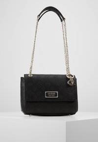 Zwarte synthetische handtas met geperst logopatroon, zilveren kettingband en een metalen merkembleem. Voorzien van een klep met sluiting en een gladde textuur.