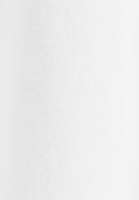 Tissu en maille blanche perforée avec de petits trous espacés régulièrement créant un motif texturé.