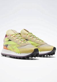 Chaussures de course vert citron et jaune avec une tige en mesh texturé, des accents contrastants orange et violet, un laçage complexe, et une semelle noire robuste.