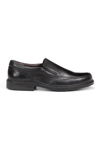 Zapato negro de cuero tipo slip-on con acabado texturizado, punta redondeada, detalles de costura sutiles y una suela baja de goma duradera.