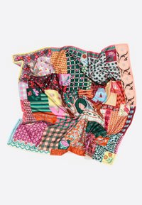 Pañuelo de seda con patrones coloridos que presenta diversos diseños, incluyendo flores, cuadros y formas geométricas, en vibrantes tonos de rojo, verde y rosa.