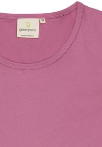T-shirt a maniche corte, girocollo, in tessuto rosa chiaro. L'etichetta riporta "greenjama" con taglia 38, prodotto in Portogallo. Tessuto morbido, senza fantasie.