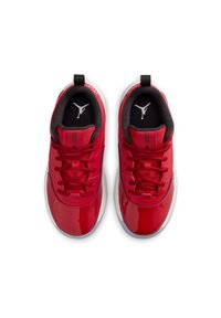 Zapatillas deportivas rojas con parte superior de charol brillante, forro textil negro, cordones planos rojos, suela blanca y un logo negro en la lengüeta.