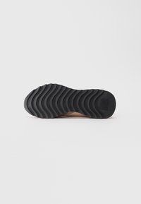 Shoe sole with black wavy rubber tread and "Blauer" brand text on the heel against a white background.