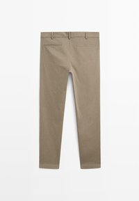 Beige bomuldsbukser med slim fit, baglommer og et enkelt design med en glat tekstur.