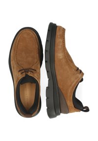 Bruine suède schoenen met een gestructureerd oppervlak, ronde neus en zwarte rubberen zool. Voorzien van veters en een leren binnenkant met branding.