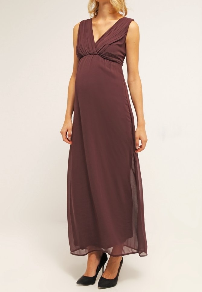 Graviditets maxi klänning i djup burgundyröd, med en plisserad V-ringning, ärmlös design och mjukt, flödande tyg med en sidoslits.