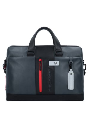 Sac de voyage en cuir gris avec des accents noirs, poche zippée rouge et étiquette amovible. Comprend des poignées doubles et une bandoulière detachable.