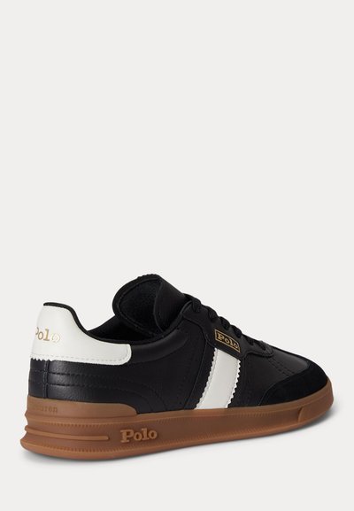 Black and white Polo brand sneaker with brown sole, lace-up design, and visible Polo logo on side and heel.