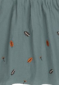 Light blue-green fabric with scattered embroidered leaves in orange, brown, and black. Smooth texture with a gathered waistband.