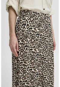 Leopardenmuster-Rock aus leichtem Material, mit einer Knopfleiste und einer weichen Textur. Die Farben umfassen Beige, Schwarz und Braun.