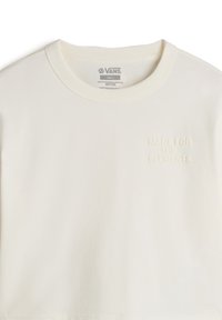 Cremefarvet bomulds t-shirt med rund hals og struktureret broderi med teksten "LAVET TIL ELEMENTERNE" på forsiden.