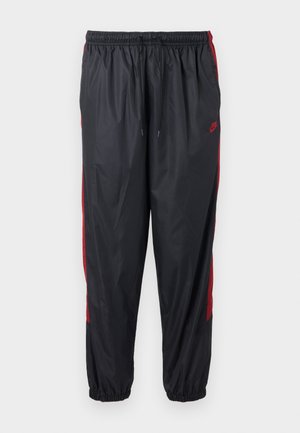 Μαύροι φόρμες Nike με κόκκινες ρίγες στο πλάι, ελαστική μέση με κορδόνι και ελαστικές μανσέτες.