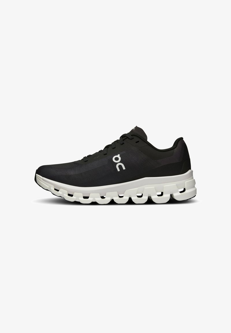 Schwarzer Sportschuh mit strukturiertem Obermaterial, weißer Zwischensohle mit einem markanten segmentierten Design und einem einfachen Logo an der Seite.