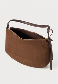 Brown suede shoulder bag with a curved design, featuring a zip closure and a brown leather strap. Gold zipper hardware visible.