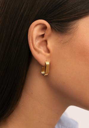 Orecchino a cerchio in oro con un design rettangolare strato su strato e una finitura liscia e lucida. Indossato all'orecchio, mette in risalto la sua forma moderna.