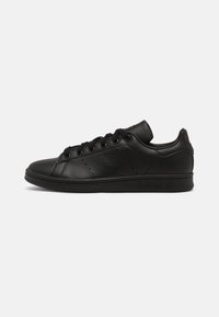 Sorte lædersneakers med rund tå, flad gummisål, snørebånd med øjer og perforerede sidedele. Logo prægede på hælen.