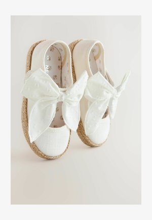 Valged espadrillid, millel on tekstuuriga kangast ülemine osa, suured kangast lipsud ja paelad jute kontsad. Õrna lillemustriga sisemus.