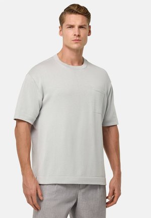 Light gray cotton t-shirt with a crew neck, short sleeves, and a front pocket. Features a relaxed fit and smooth texture.