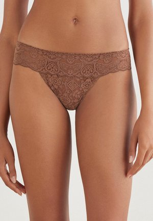 Bruine kanten thong met bloemmotieven en een geschulpte tailleband. Zachte textuur, minimalistische dekking en zichtbare naaddetails.