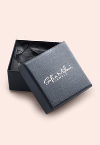 Scatola per gioielli nera con texture, con il coperchio parzialmente aperto che rivela un tessuto nero accartocciato all'interno e il marchio "Sofia Milani Jewels" in bianco.