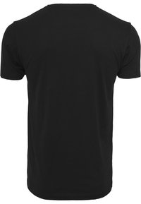 T-shirt en coton noir avec un col rond et des manches courtes. Texture lisse, coupe standard, sans logos ni motifs visibles au dos.
