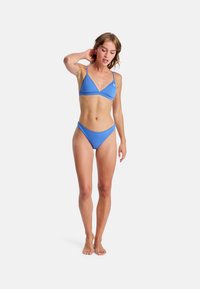 Ensemble bikini bleu comprenant un haut triangulaire et un bas taille basse, fabriqué en tissu lisse avec un design minimaliste.