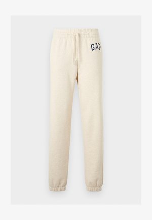 Béžové elastické tepláky s povrazcom a elastickými manžetami, s tmavomodrým logom "GAP" na hornej ľavej stehne.