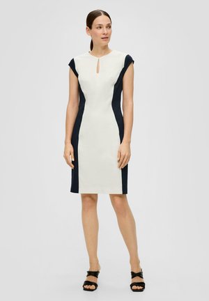 Robe cintrée en crème clair avec des panneaux latéraux bleu marine, décolleté en clé et manches courtes. Texture lisse et design à hauteur du genou.