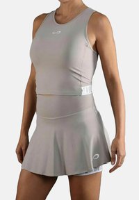 Top deportivo en color gris claro con un ajuste ceñido en la cintura y una falda acampanada. Fabricado en material elástico, presenta un logo en la parte delantera y en la cinturilla.