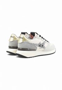 Baskets avec une tige en textile blanche et grise, lacets noirs, accents argentés et un détail étoile scintillant. Elles disposent d'une semelle rembourrée et d'un talon marqué.