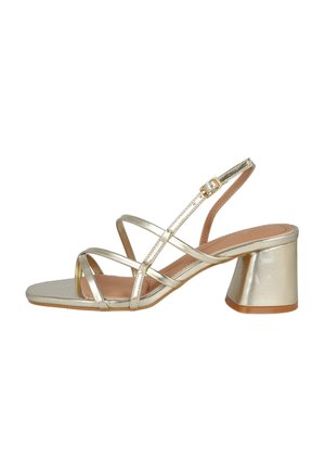 Sandalia metálica dorada con tiras, tacón bajo y ancho, correa con hebilla en el tobillo y diseño de punta cuadrada sobre fondo blanco.