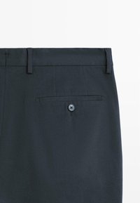 Námořnické modré kalhoty s elegantním designem, vybavené jednou zadní kapsou na knoflík a poutky na opasek po obvodu pasu.