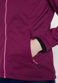 Fleecejacke in Dunkelpink mit durchgehendem Frontreißverschluss mit pinkfarbenen Akzenten, Reißverschlusstasche und schwarzer Kante an der Manschette.