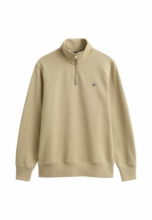 Pull-over beige à manches longues avec une fermeture éclair quart de longueur et un petit logo brodé sur le côté gauche de la poitrine, doté de poignets et d'un ourlet côtelés.